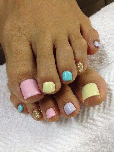 Pastel multi-color pedicure with a gold-glitter accent toe — real work by US Nails
