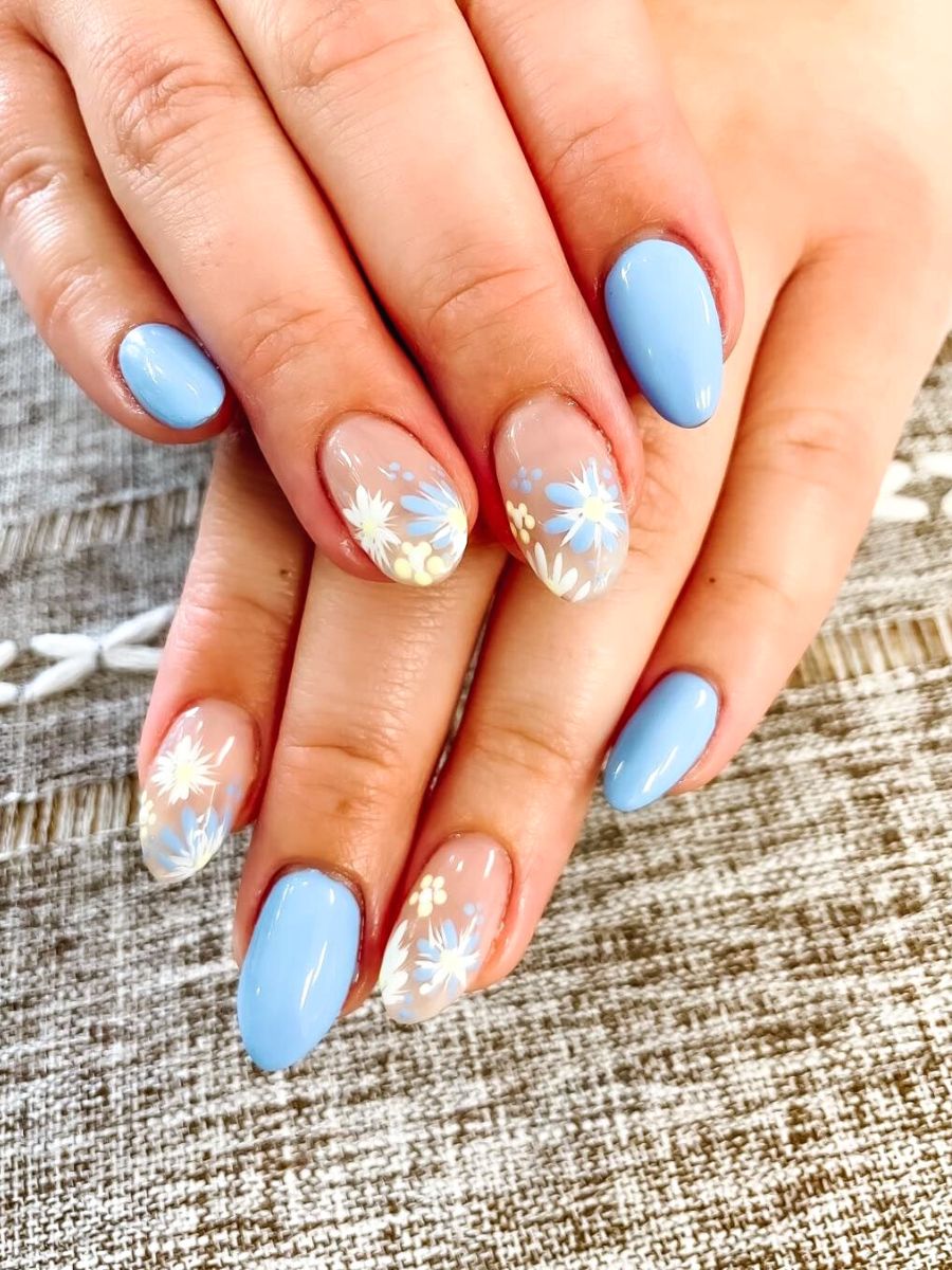 Sky-blue nails with hand-painted white daisy florals — real work by US Nails